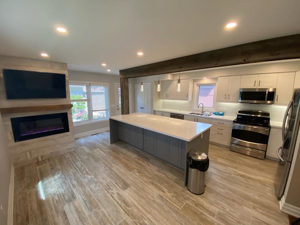 Renovated open-concept kitchen with island, fireplace and wood beam